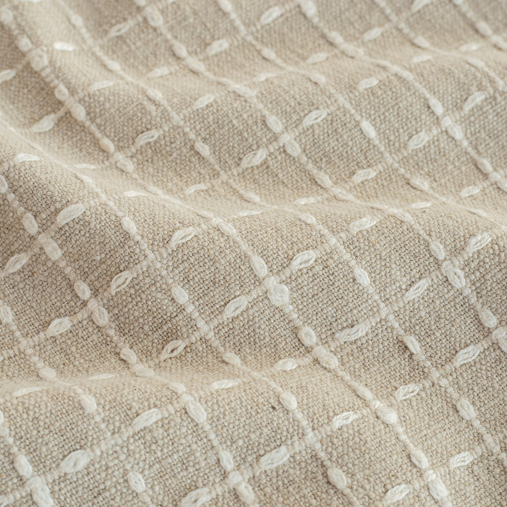 a beige with cream windowpane stitch pattern home decor fabric : close up view