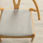 Warm grey Chester Pebble herringbone upholstery fabric by Tonic Living shown on a dining chair seat.