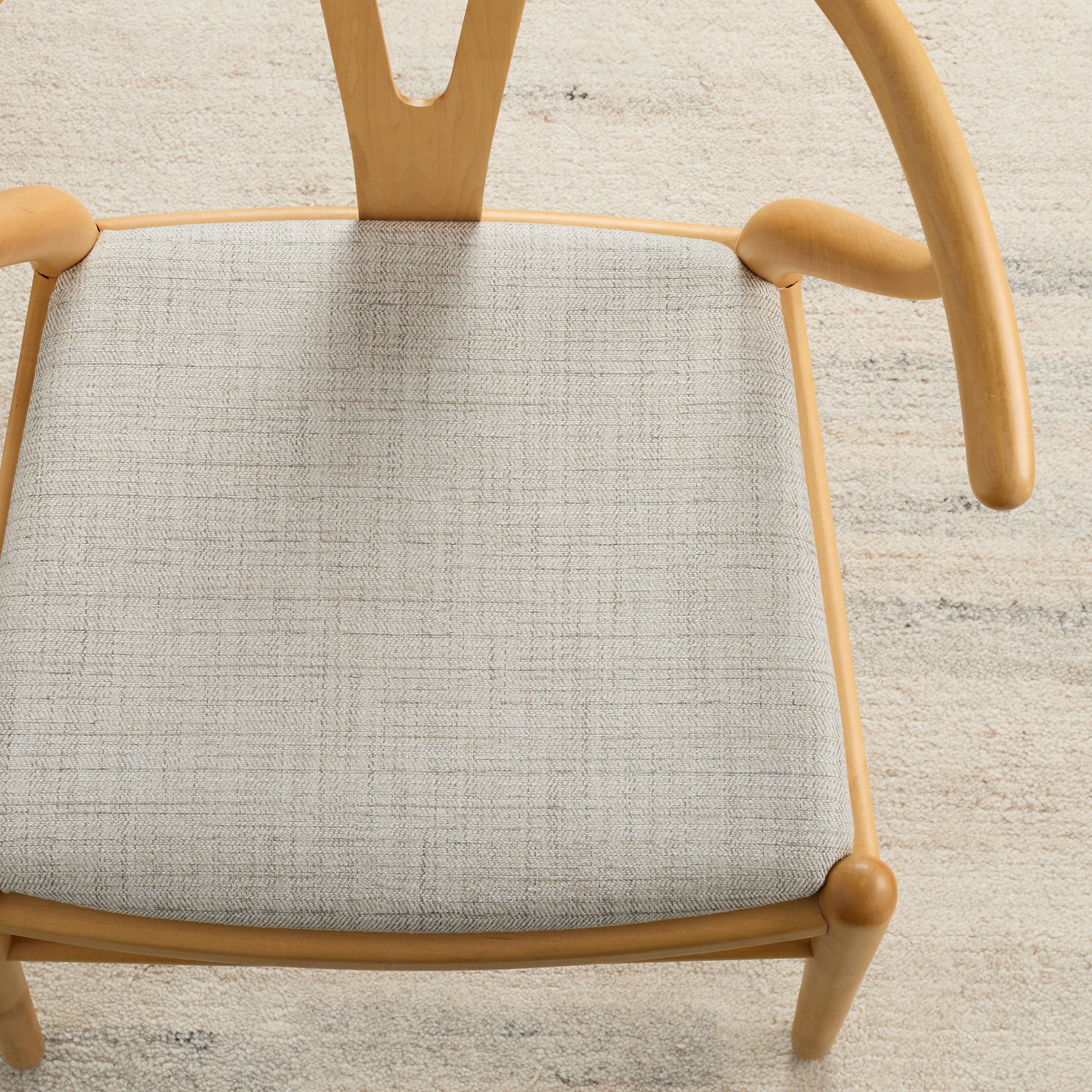 Warm grey Chester Pebble herringbone upholstery fabric by Tonic Living shown on a dining chair seat.