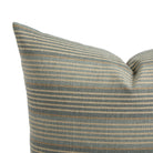 Close up of Tonic Living Clark Stripe Pool pillow showing faded blue, oatmeal, and camel stripes with woven texture.