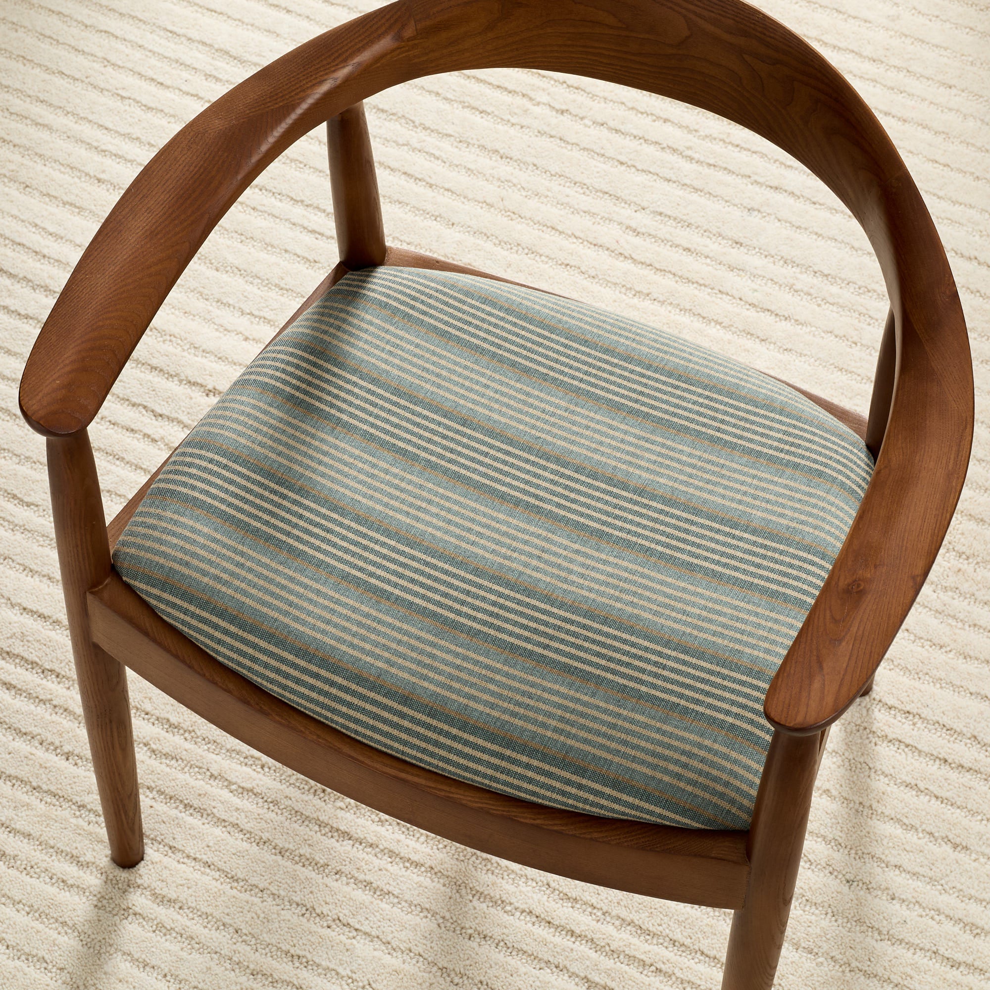 Tonic Living Clark Stripe Pool high-performance fabric shown upholstered on a dining chair seat with muted blue stripes.