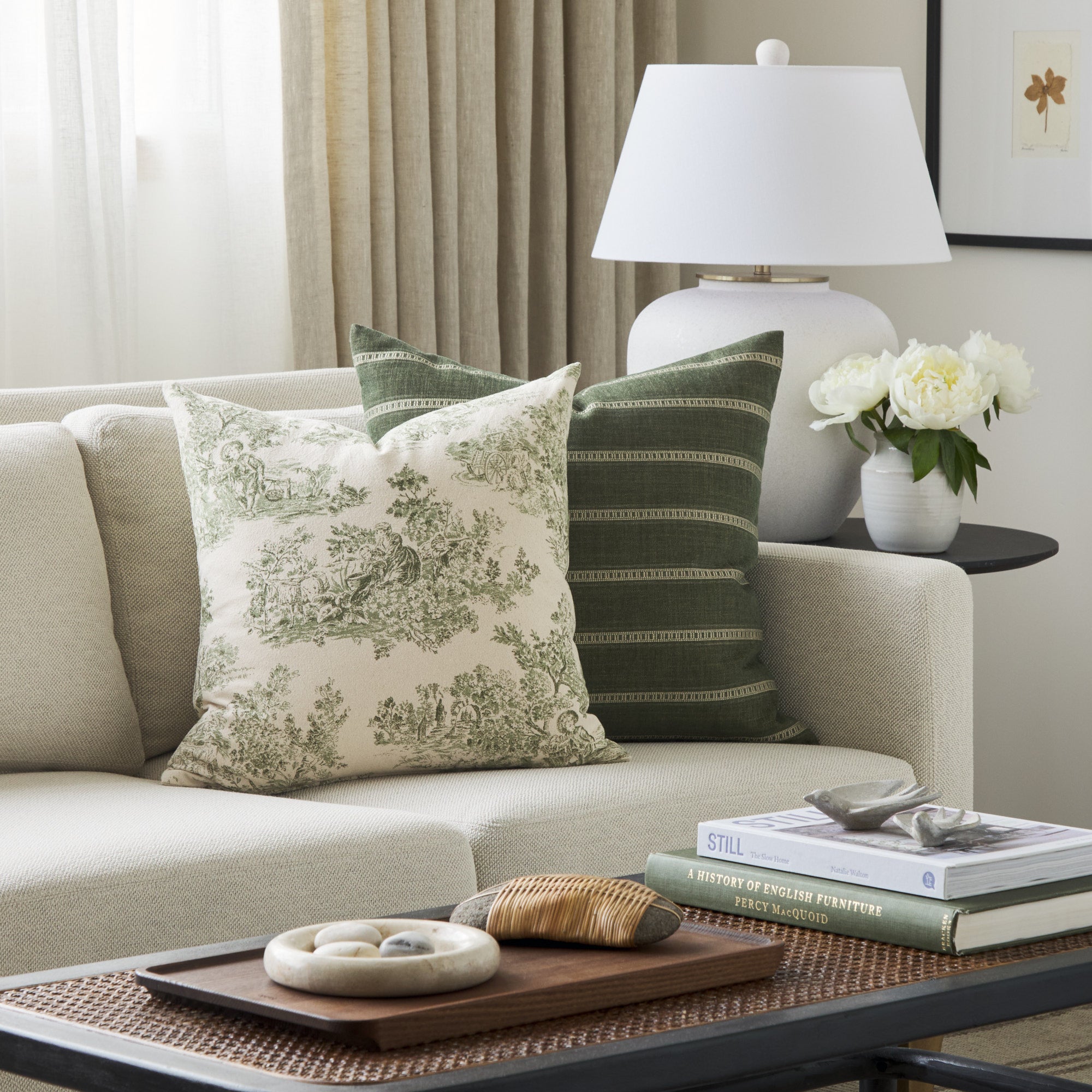 Tonic Living Colette Forest Green decorative pillow styled on a sofa with the Brunswick Stripe 22x22 Pillow in Moss.