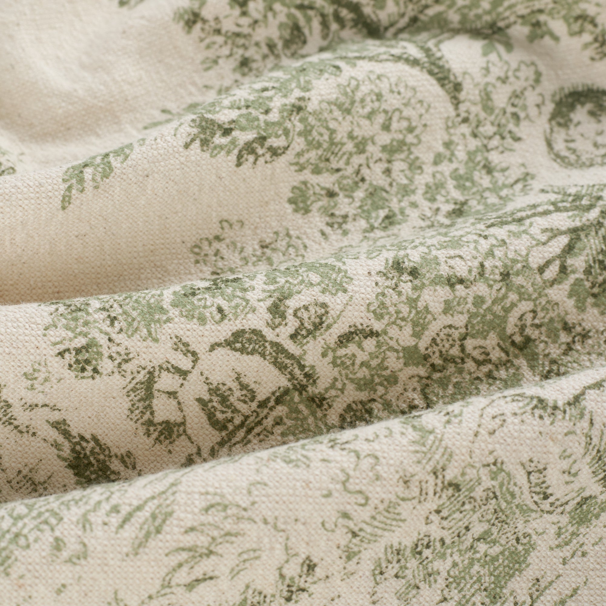 Close up of Tonic Living Colette Forest Green fabric showing scenic toile detail in forest green and beige.