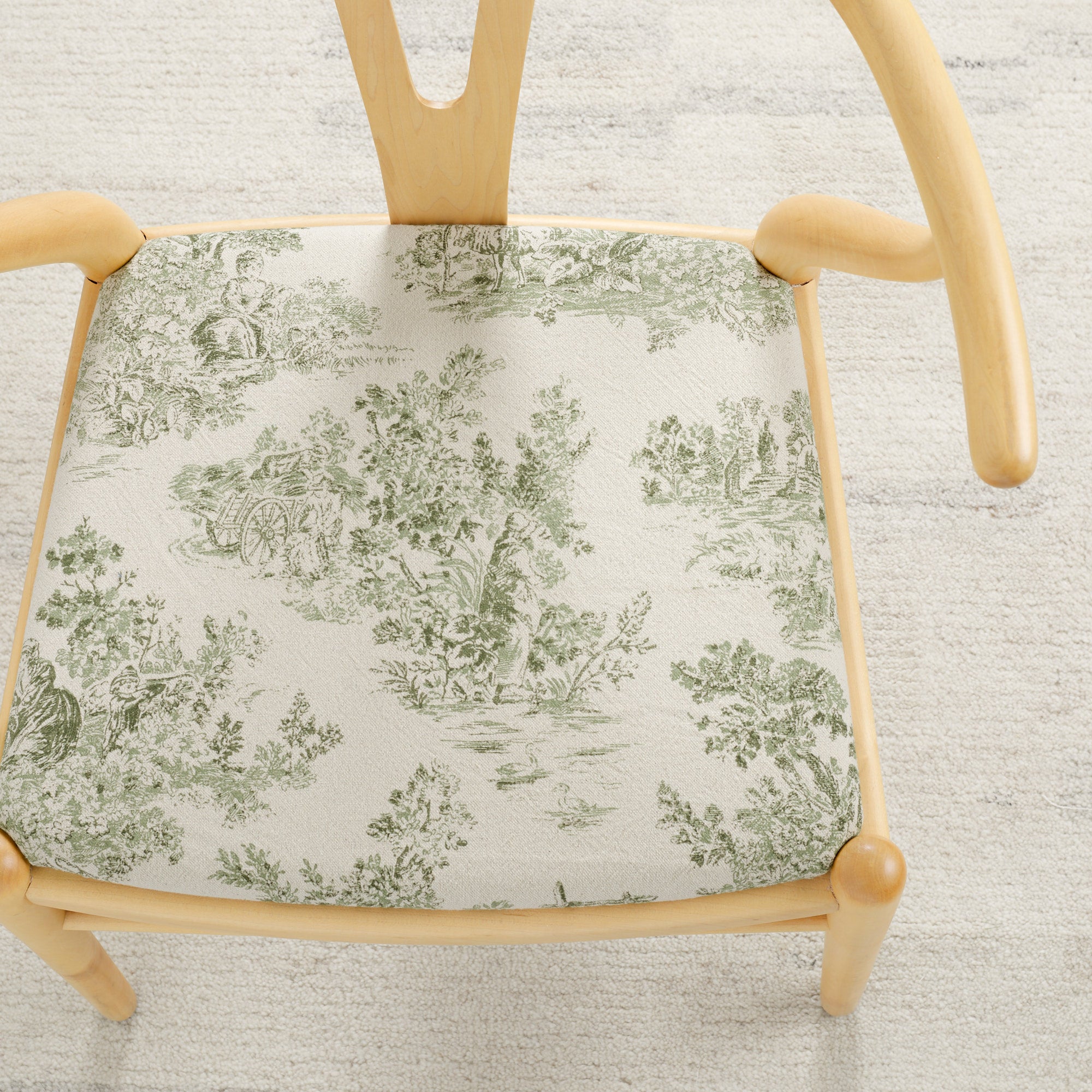 Tonic Living Colette Forest Green upholstery fabric shown on a chair seat with a French toile pattern.