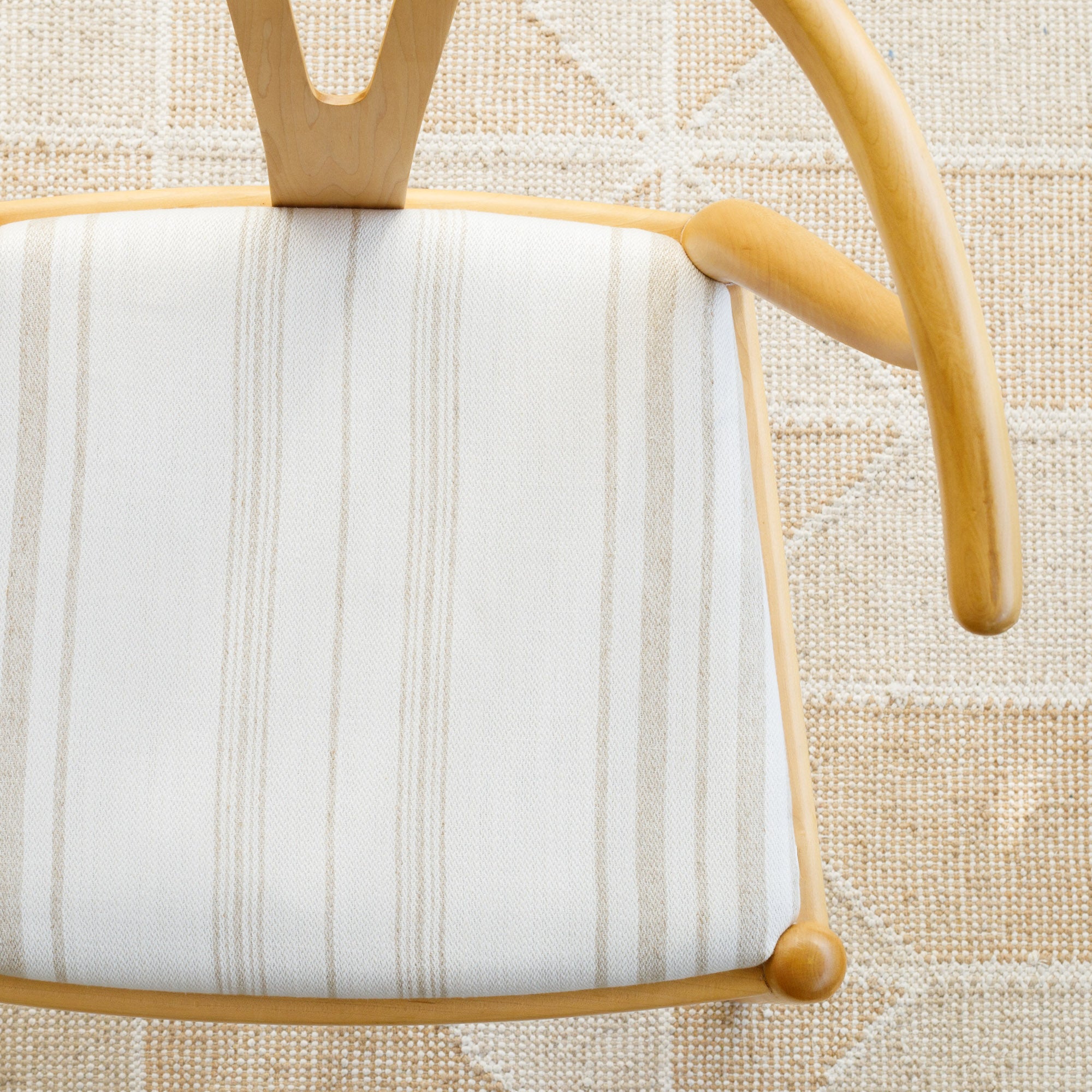 a white and beige vertical striped fabric chair seat
