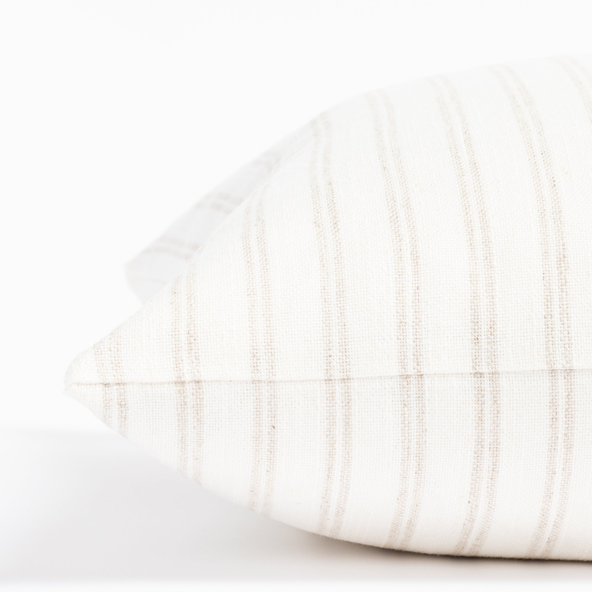 a soft white and beige vertical stripe style throw pillow : close up side view