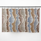 Full yard of Tonic Living Cortina Fabric in Storm hanging to show the scale of its blue and brown organic abstract pattern.