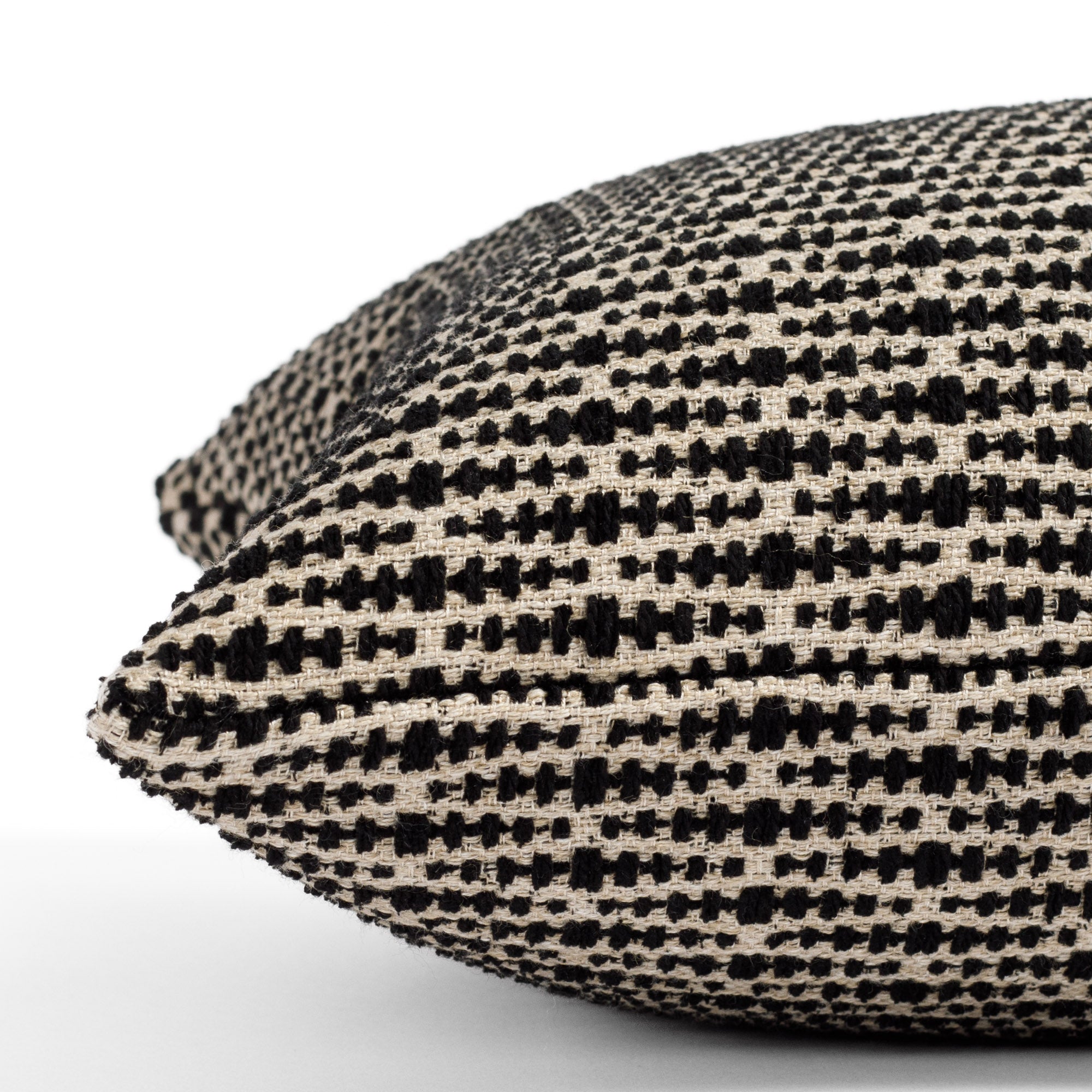 a black and tan geometric patterned lumbar pillow : close up side view