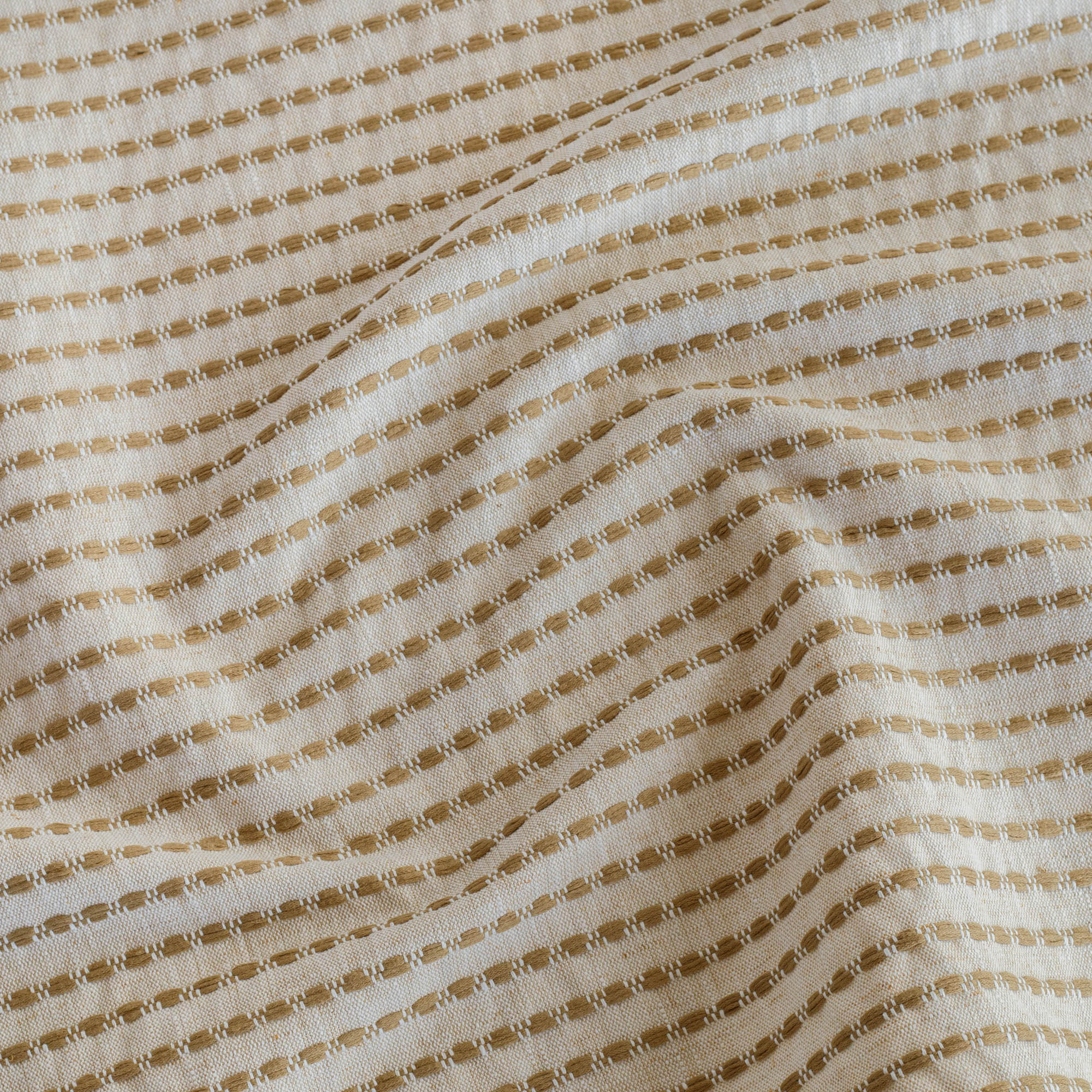 Detail view of Tonic Living Dash Stripe Ochre small-scale striped upholstery fabric.