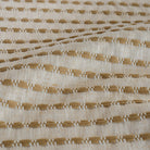 Close-up of Tonic Living Dash Stripe Ochre golden camel striped upholstery fabric.