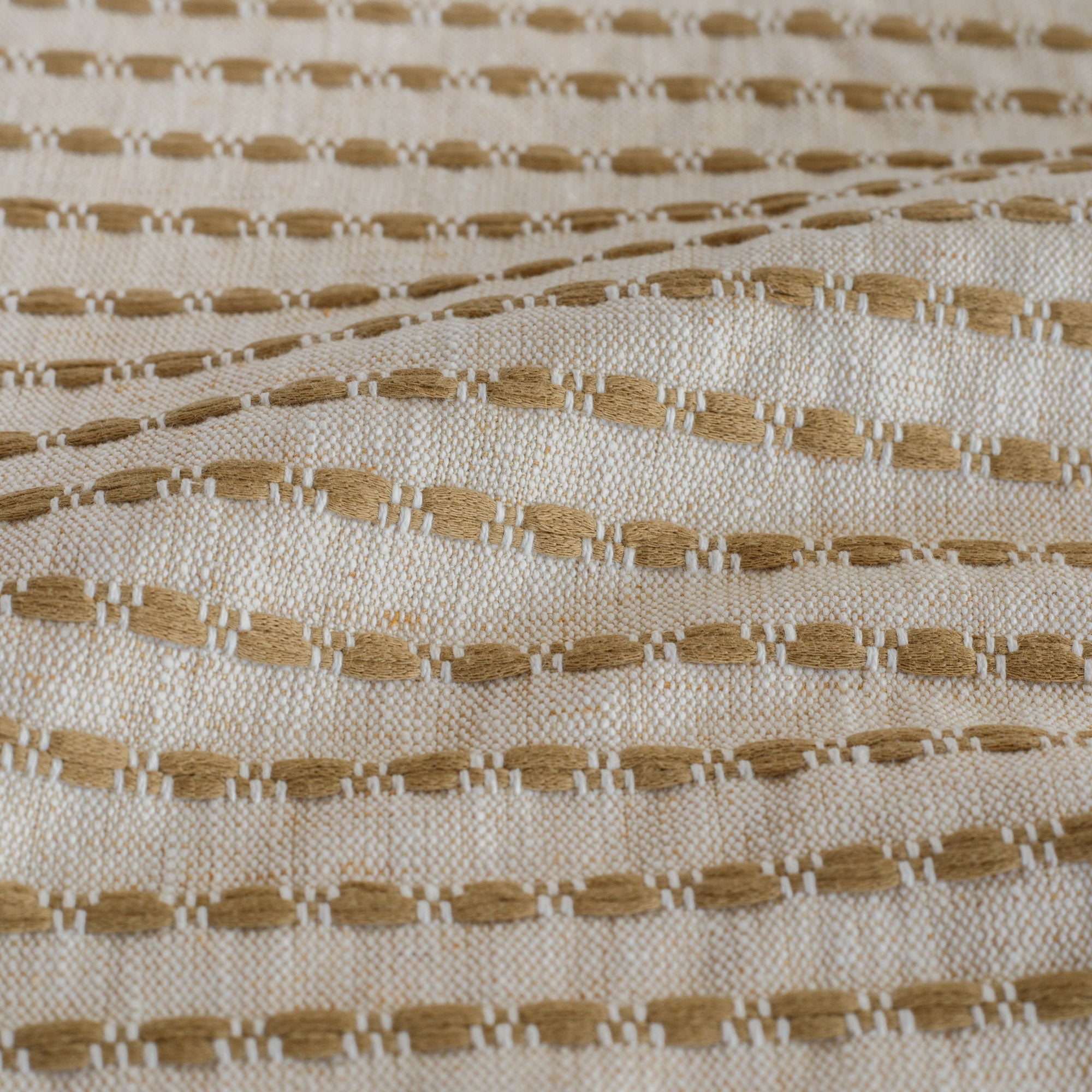 Close-up of Tonic Living Dash Stripe Ochre golden camel striped upholstery fabric.