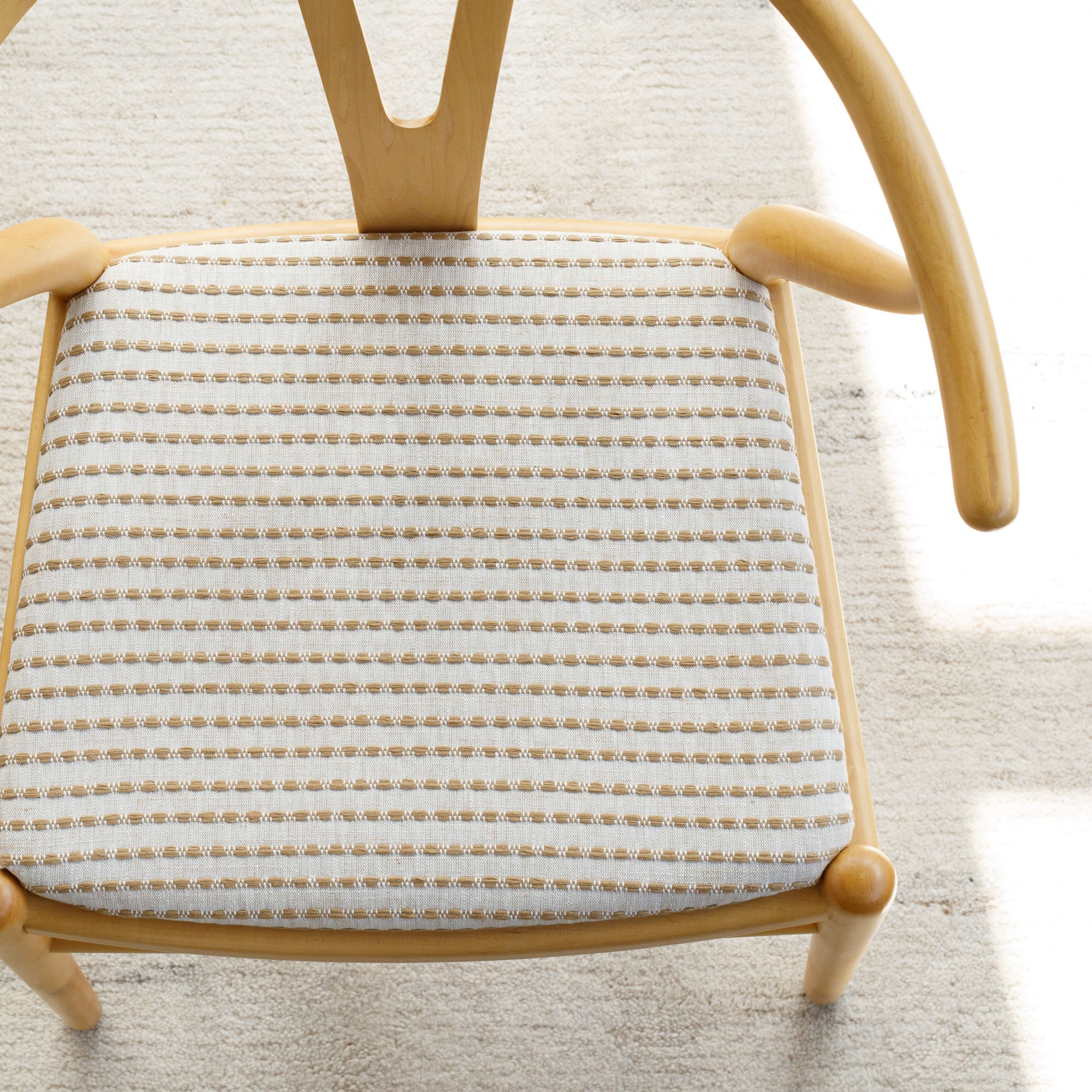 Tonic Living Dash Stripe Ochre striped neutral upholstery fabric on dining chair.