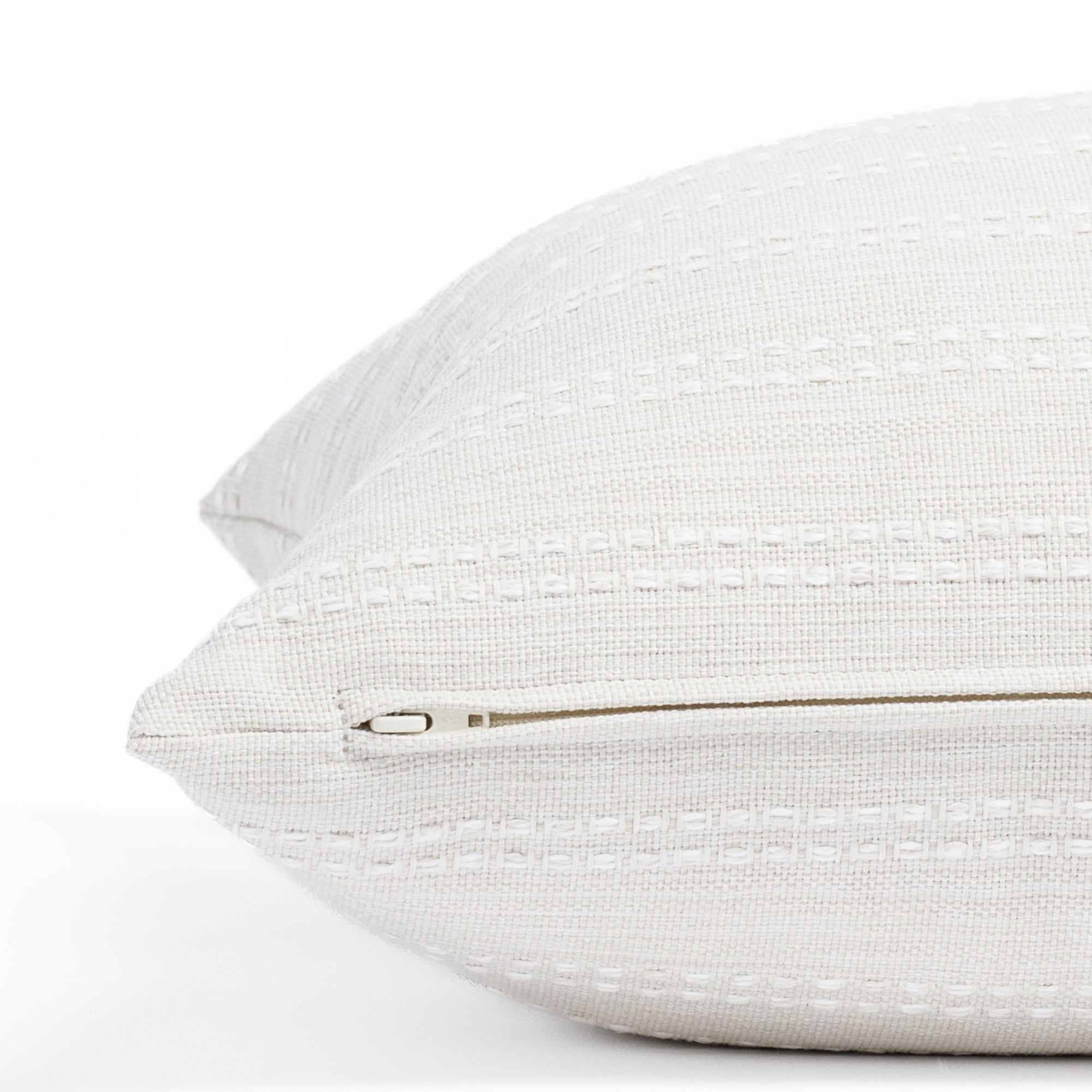 a soft white tonal stripe throw pillow: close up zipper view