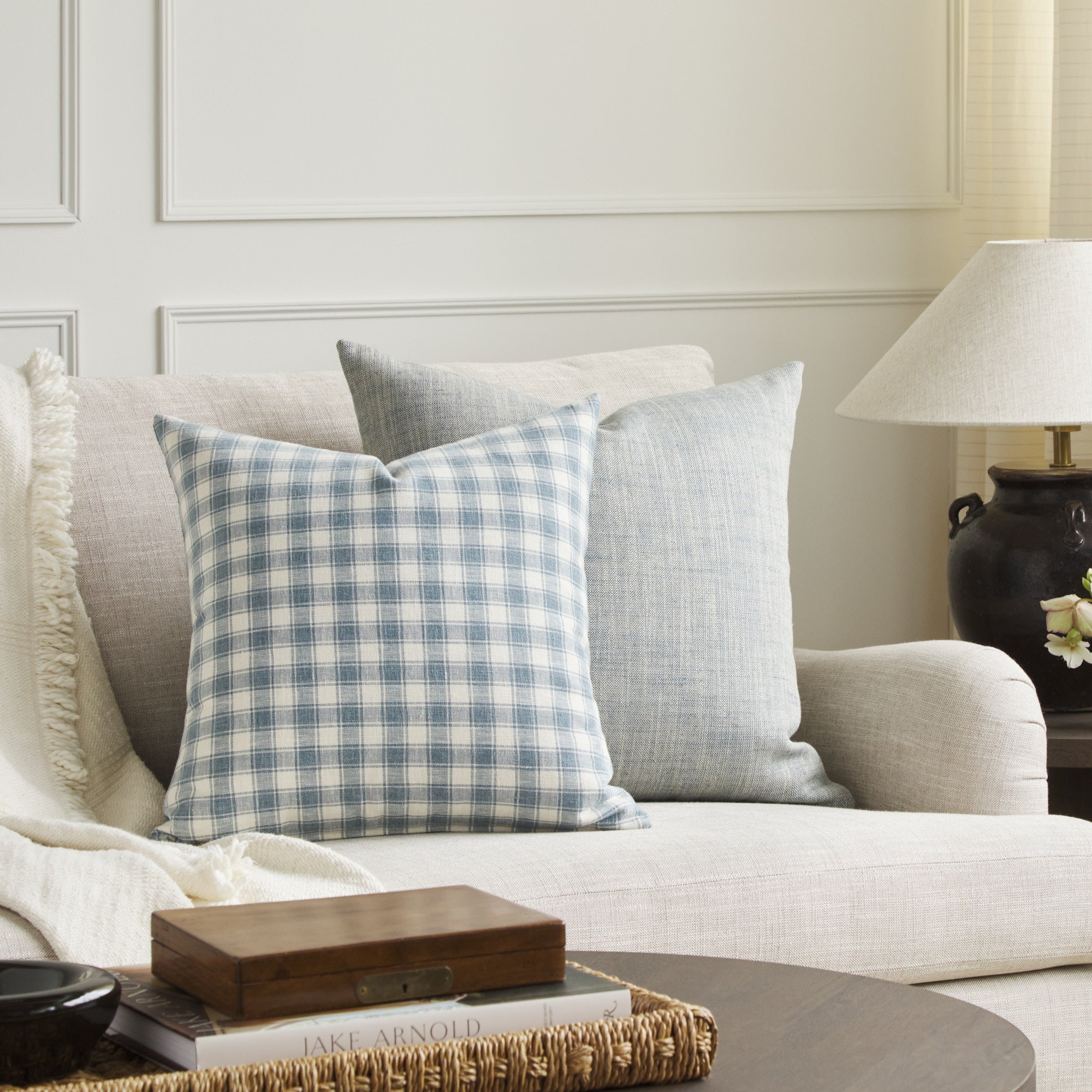 Tonic Living Emmett Plaid blue throw pillow styled on a sofa with the Brussels 22x22 Pillow in Sky Blue.