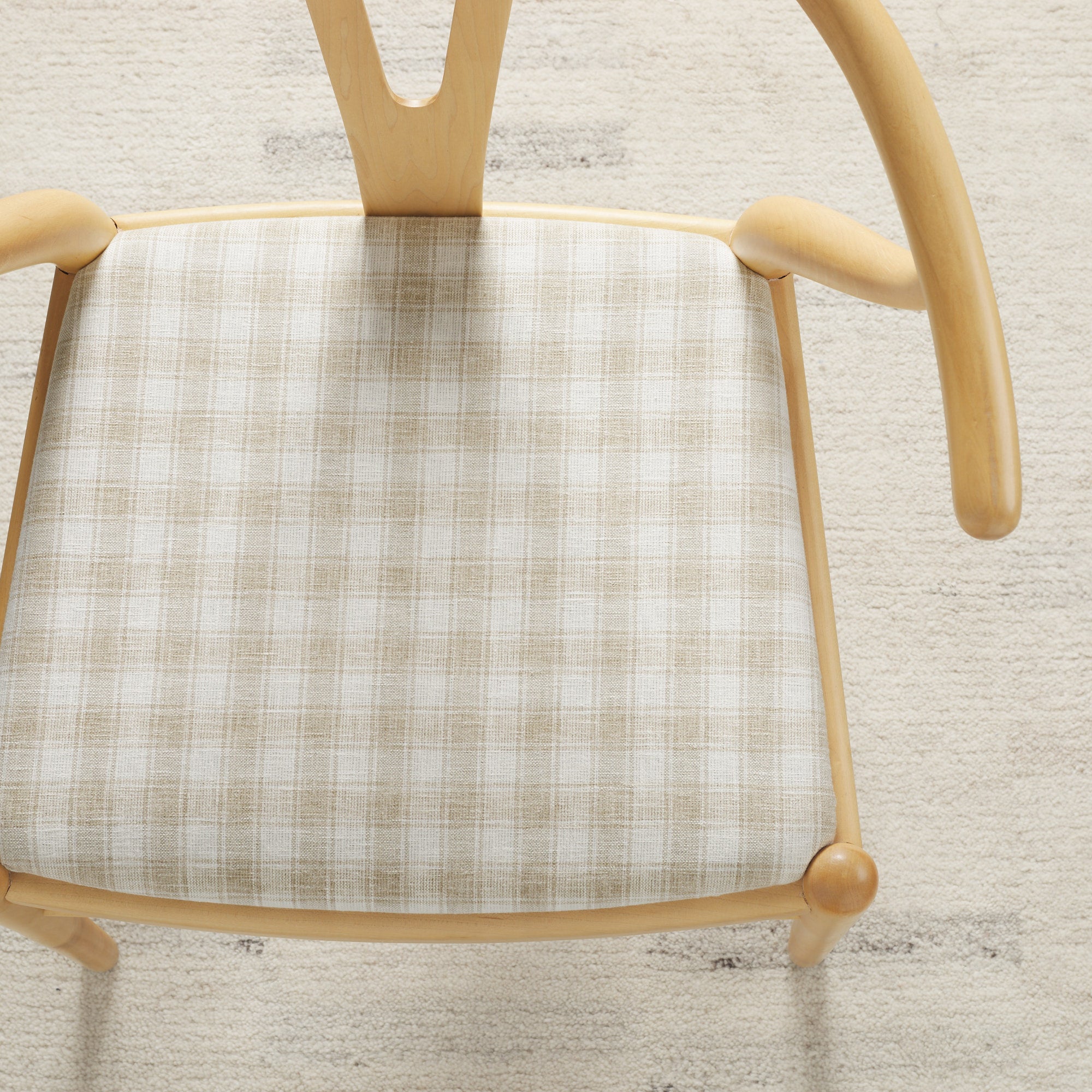 Tonic Living Emmett Plaid Flax upholstery fabric shown on a dining chair in a classic beige and white plaid.