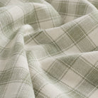 Close up of Tonic Living Emmett Plaid Sage fabric featuring a timeless light green plaid pattern.