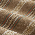 Close up of Tonic Living Fisher Stripe Cinnamon fabric showing nutty brown, wheat, orange, and deep teal stripes.