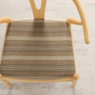 Tonic Living Fisher Stripe Cinnamon high-performance upholstery fabric on a dining chair in warm earthy stripe.