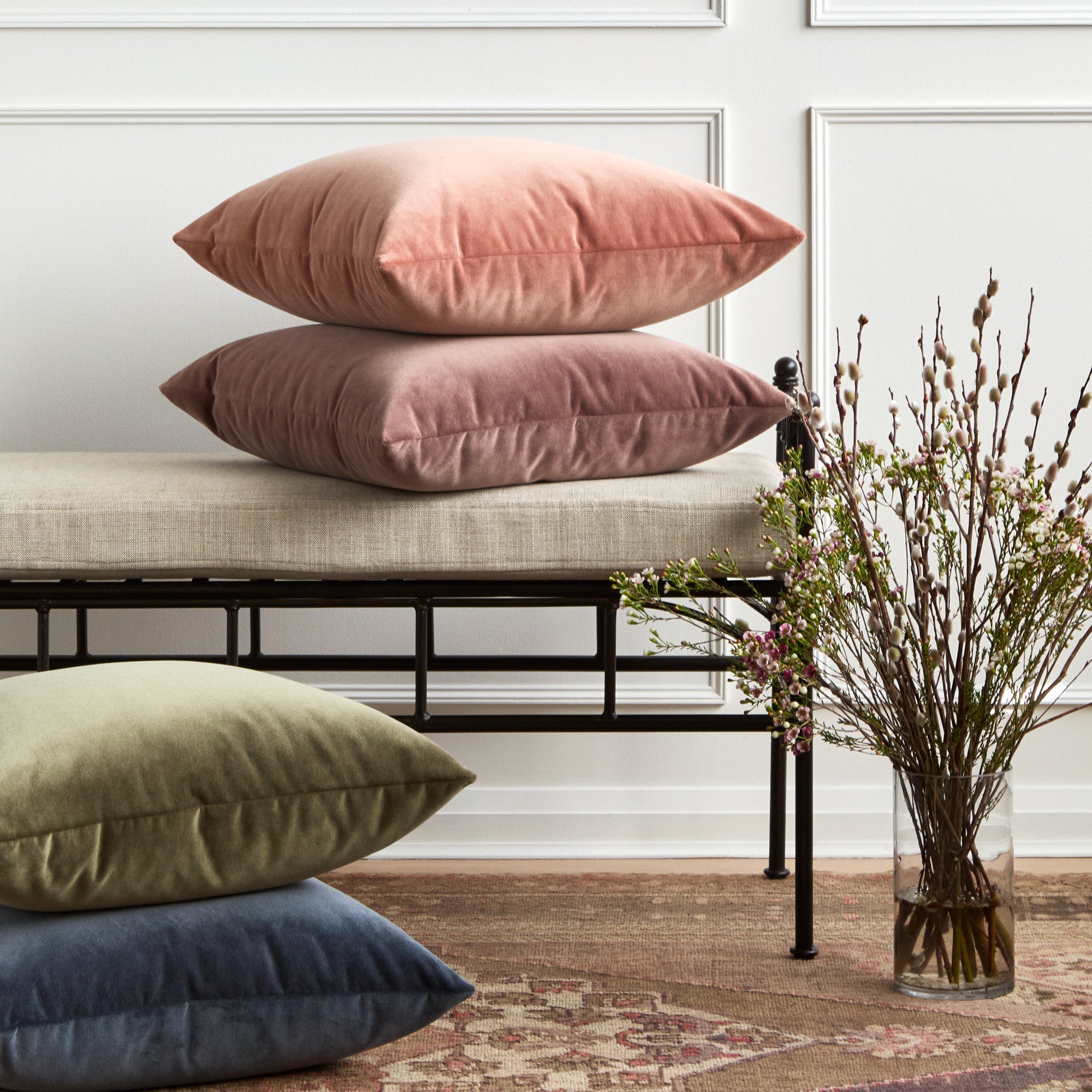 Tonic Living Florence Velvet throw pillows in pink, green, blue, and mauve styled together on a bench.