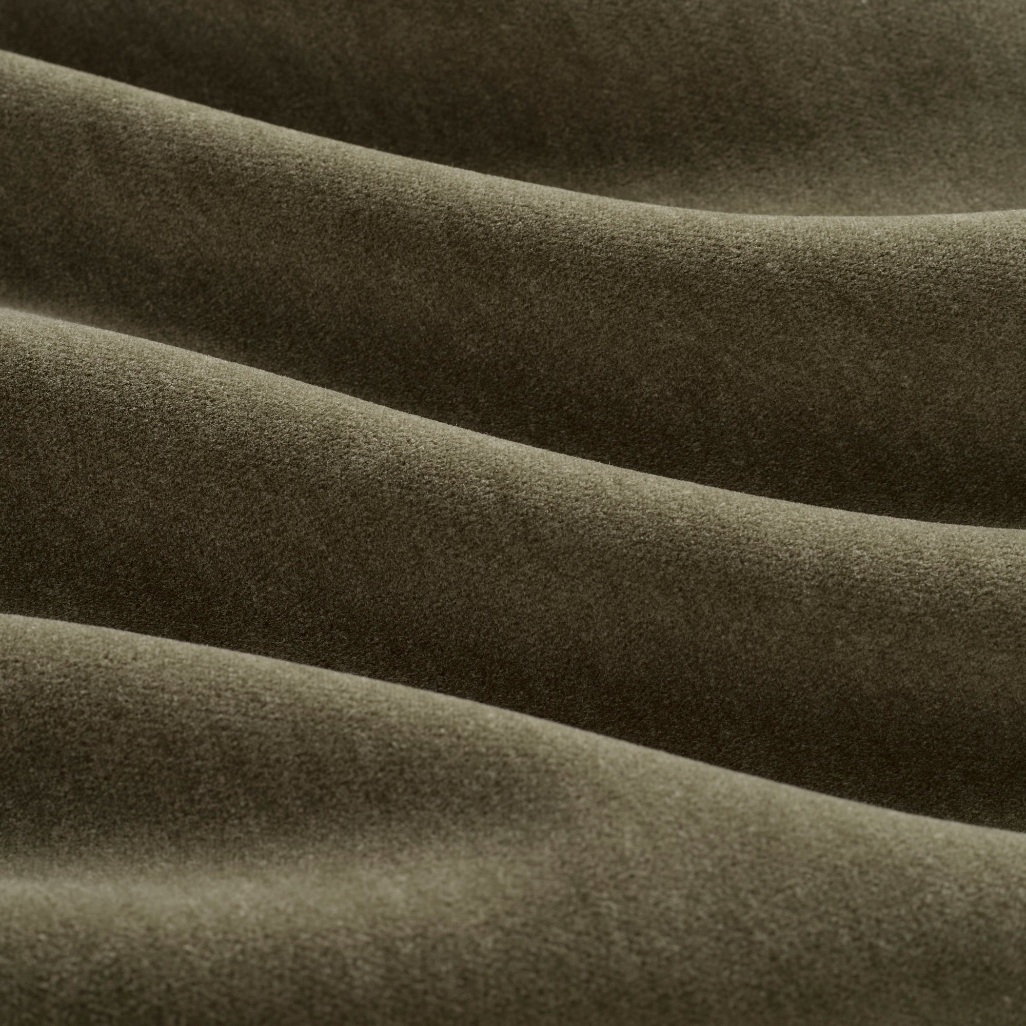 Close up of Tonic Living Florence Velvet Olive upholstery fabric showing its plush green velvet texture.