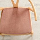 Tonic Living Florence Velvet Rosewood upholstery fabric shown on a dining chair in peachy pink velvet.