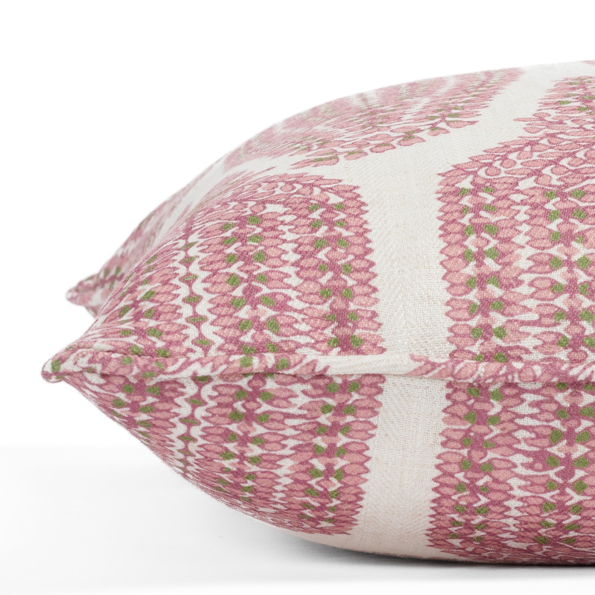 Close-up side view of a pink, leafy green and natural pillow with piped detail and botanical pattern (Georgia Orchid Pink 20x20 pillow from Tonic Living).