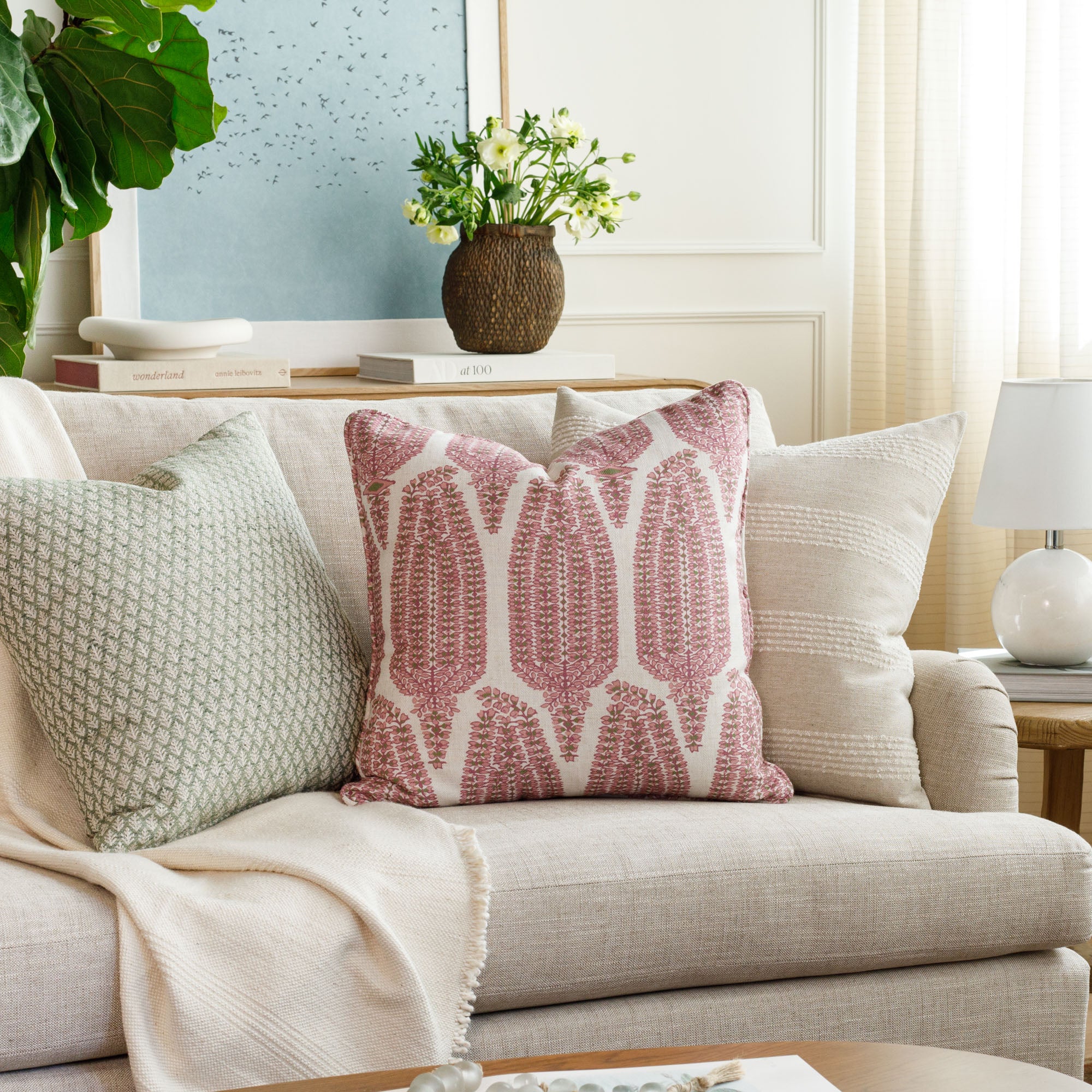 Three colourful designer pillows from Tonic Living—Liora Pink, Georgia Orchid Pink, and Finn Stripe Natural—styled on a sofa in a beautifully layered living room setting.