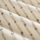 Close up of Tonic Living Hadley Stripe drapery fabric showing its detailed bamboo-inspired stripes in blue and light brown on off-white.