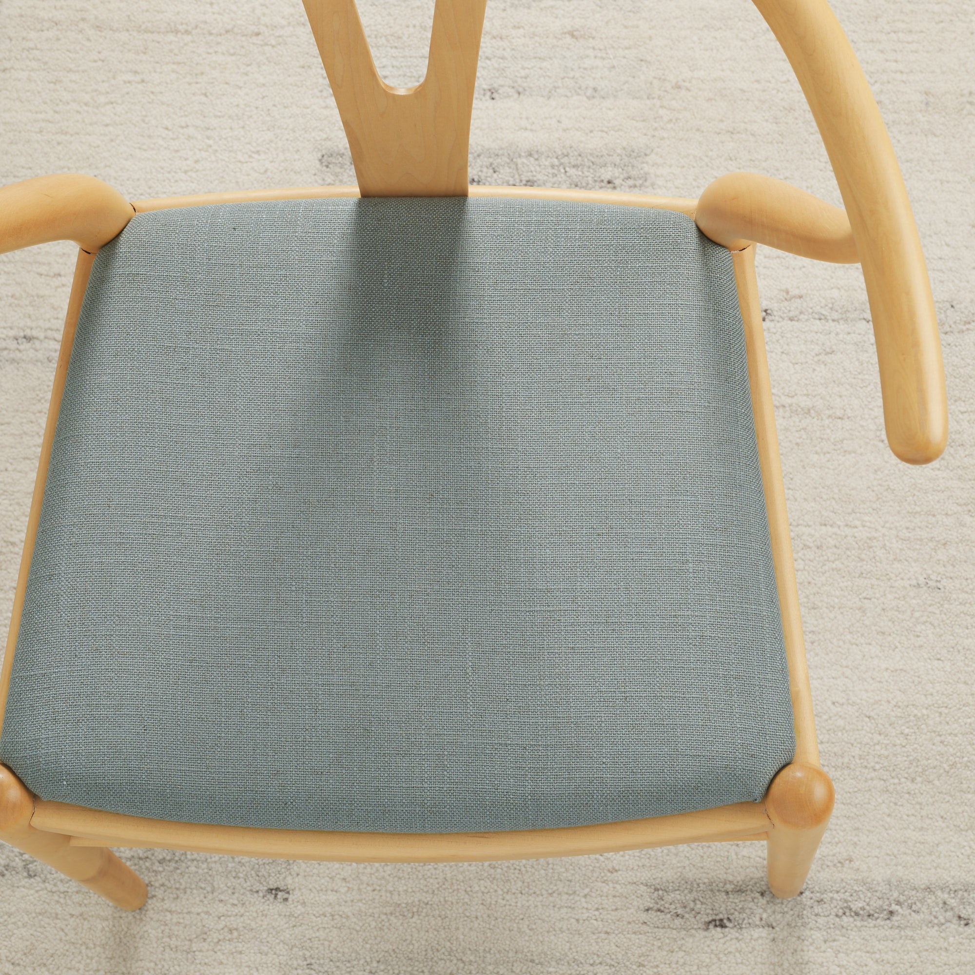 Tonic Living Hampton Chambray high-performance upholstery fabric on a dining chair seat in soft blue linen-look texture.