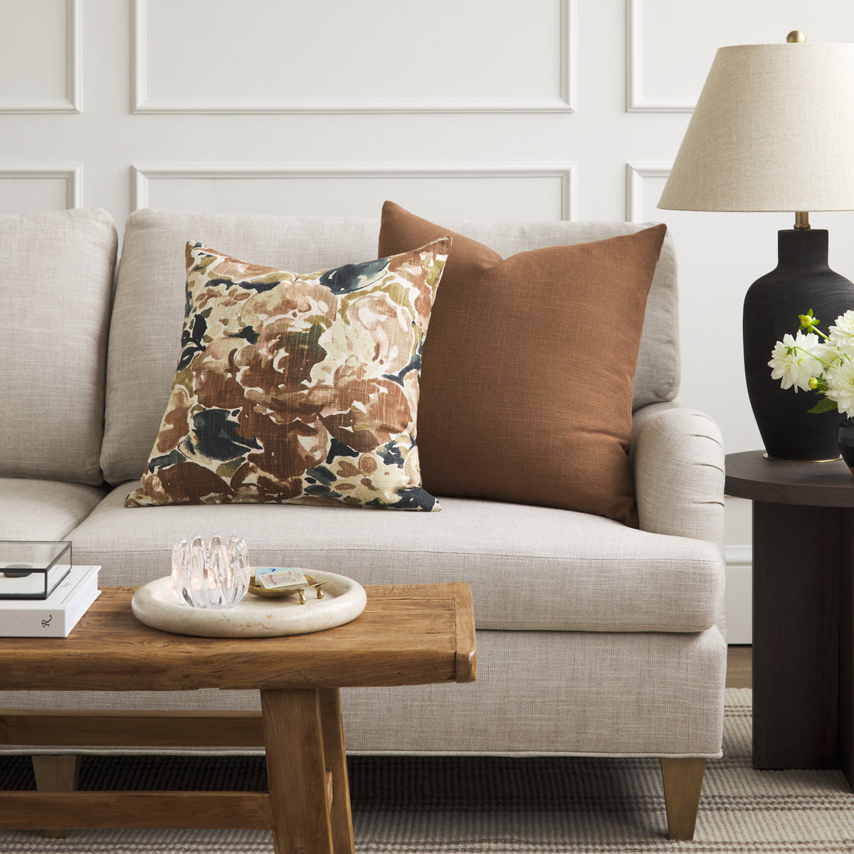 Tonic Living Hampton Cinnamon brown cushion styled on a sofa with Marbella Inkwell abstract floral pillow.