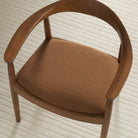 Tonic Living Hampton Cinnamon high-performance upholstery fabric shown on a dining chair seat in a warm russet brown.