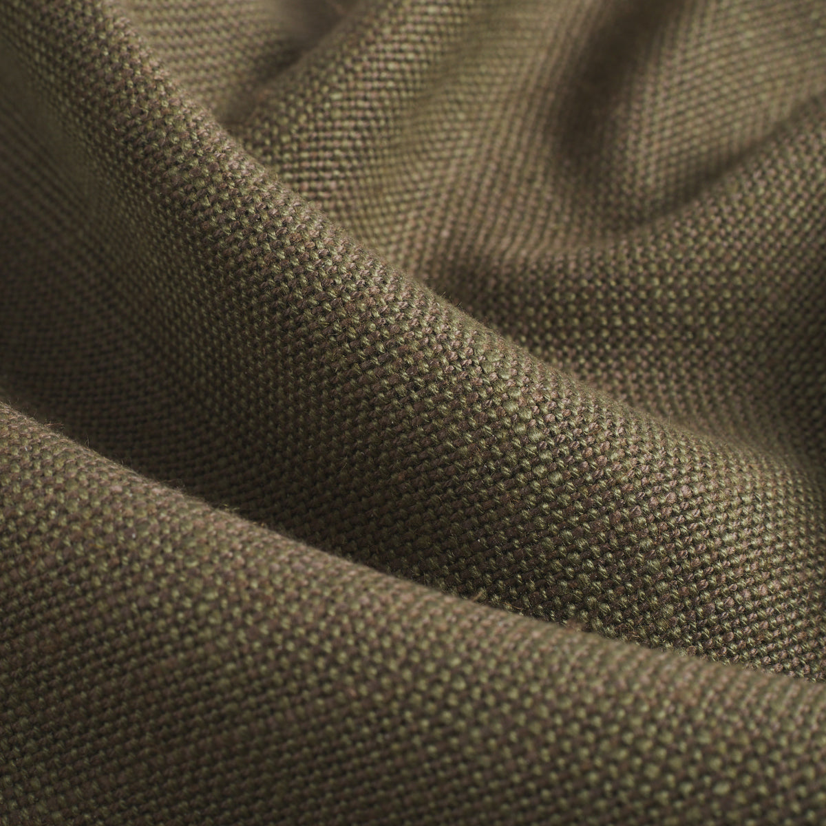 Close up of Tonic Living Hampton Moss upholstery fabric showing its earthy green colour, moss tones, and linen-like woven texture.