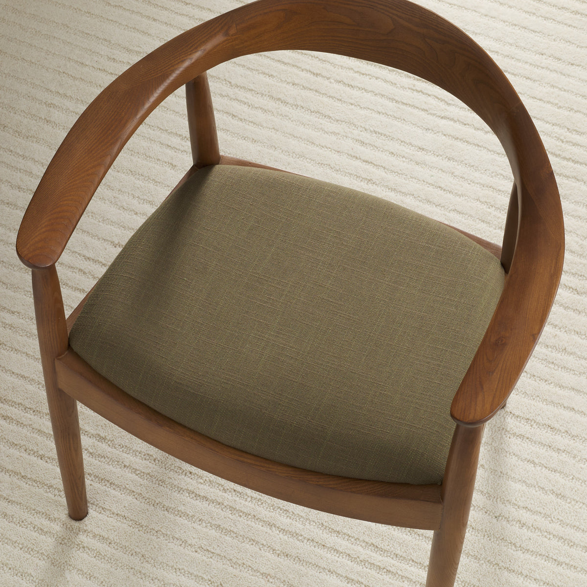 Tonic Living Hampton Moss high-performance upholstery fabric shown on a dining chair seat in a rich moss green.