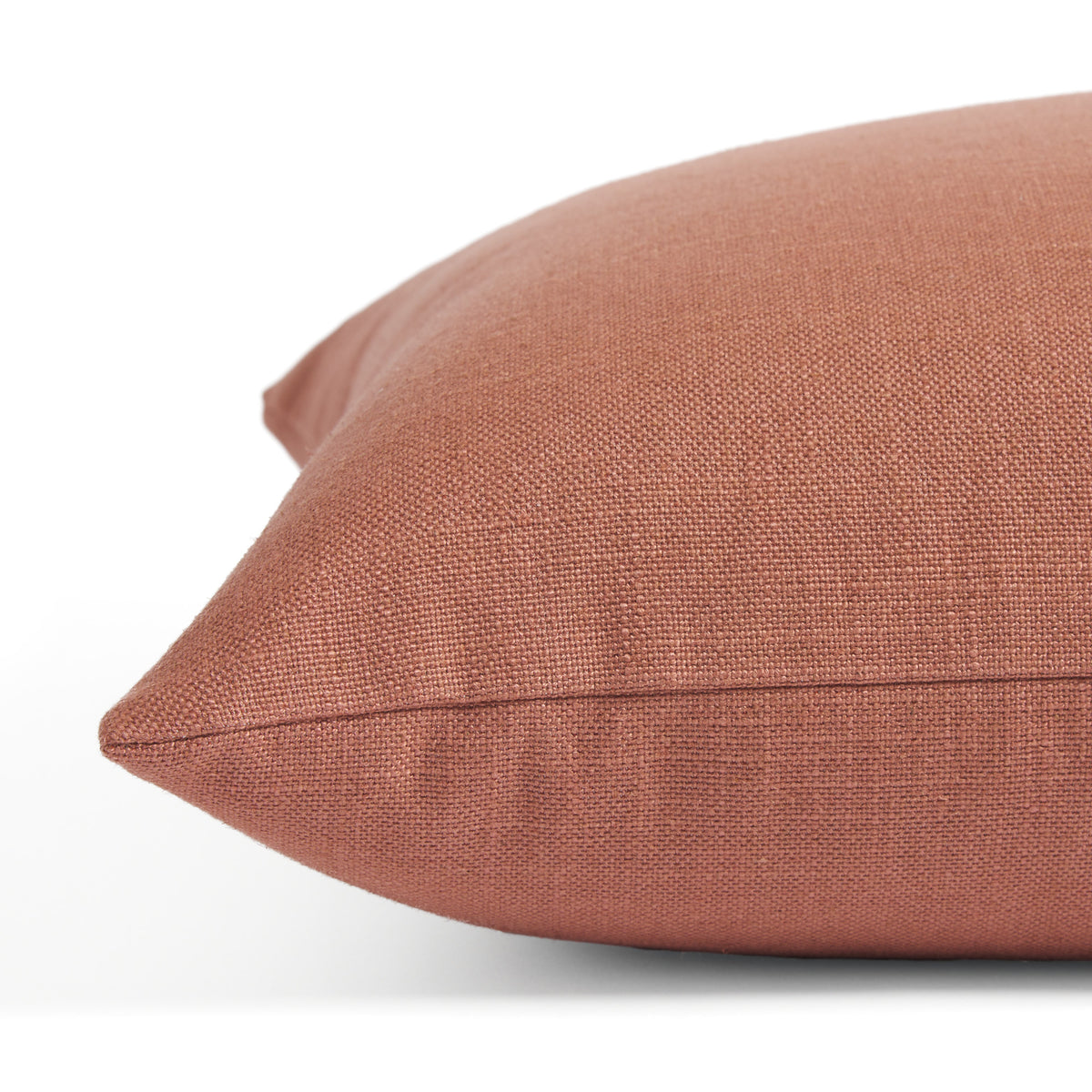 Side view of Tonic Living Hampton Rosewood toss cushion highlighting its warm pink terracotta colour and linen-look texture.