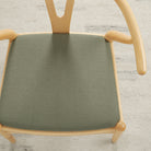 Tonic Living Hampton Sage high-performance upholstery fabric on a dining chair seat in soft earthy green linen-look texture.