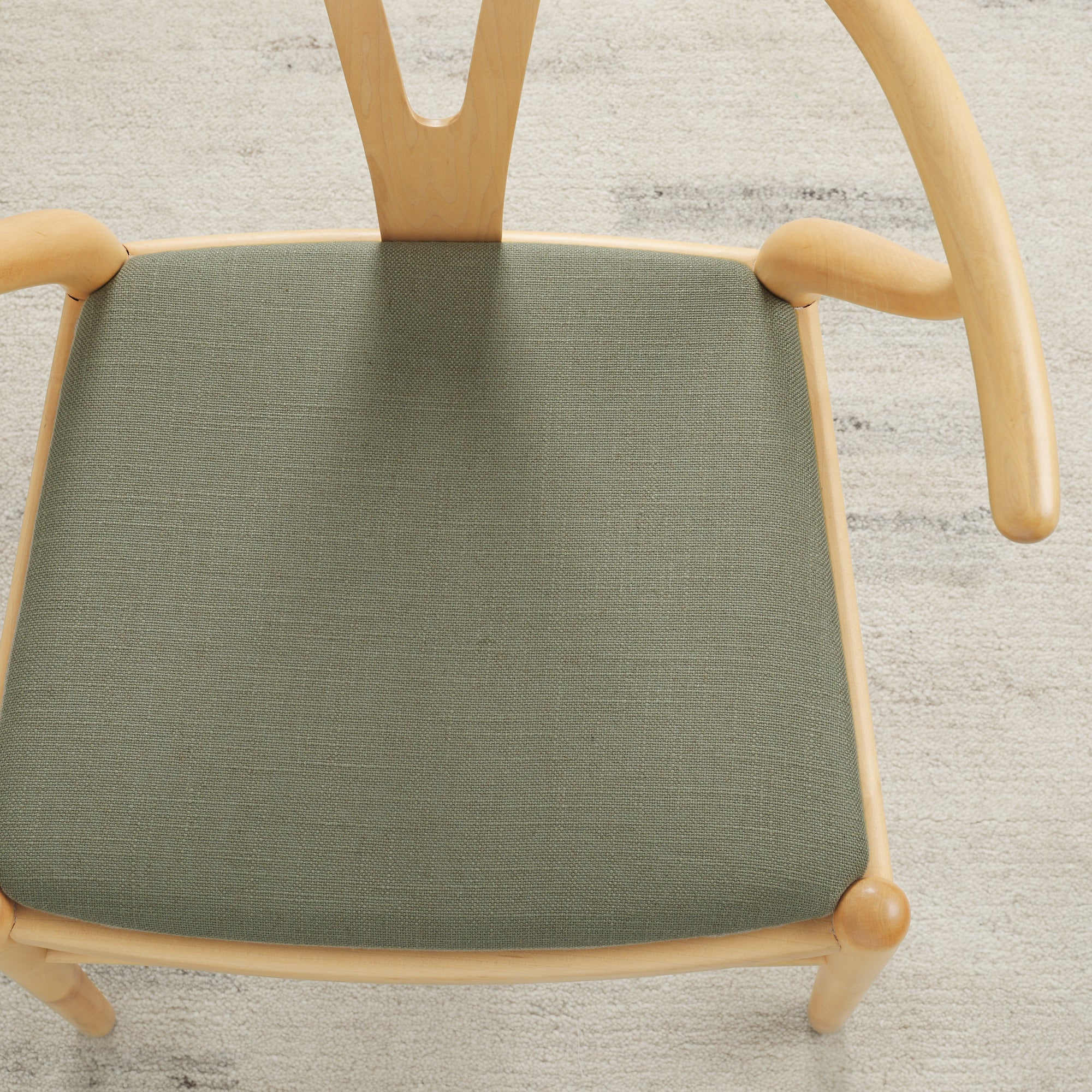 Tonic Living Hampton Sage high-performance upholstery fabric on a dining chair seat in soft earthy green linen-look texture.