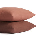Stack of Tonic Living Hampton pillows in Rosewood earthy pink and Burgundy deep red-brown with linen-inspired texture.