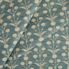 Tonic Living Hazel Pool floral upholstery fabric featuring a delicate botanical design in muted teal blue and oatmeal.