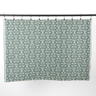 Full yard of Tonic Living Hazel Fabric in Pool hanging to show the scale of its muted teal blue and oatmeal botanical pattern.