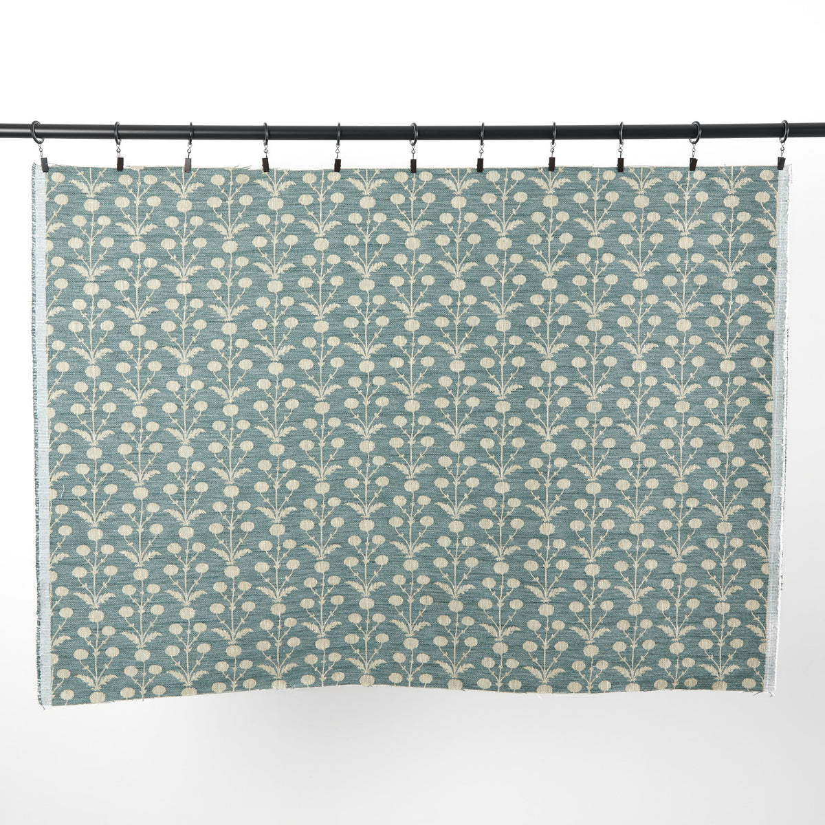 Full yard of Tonic Living Hazel Fabric in Pool hanging to show the scale of its muted teal blue and oatmeal botanical pattern.