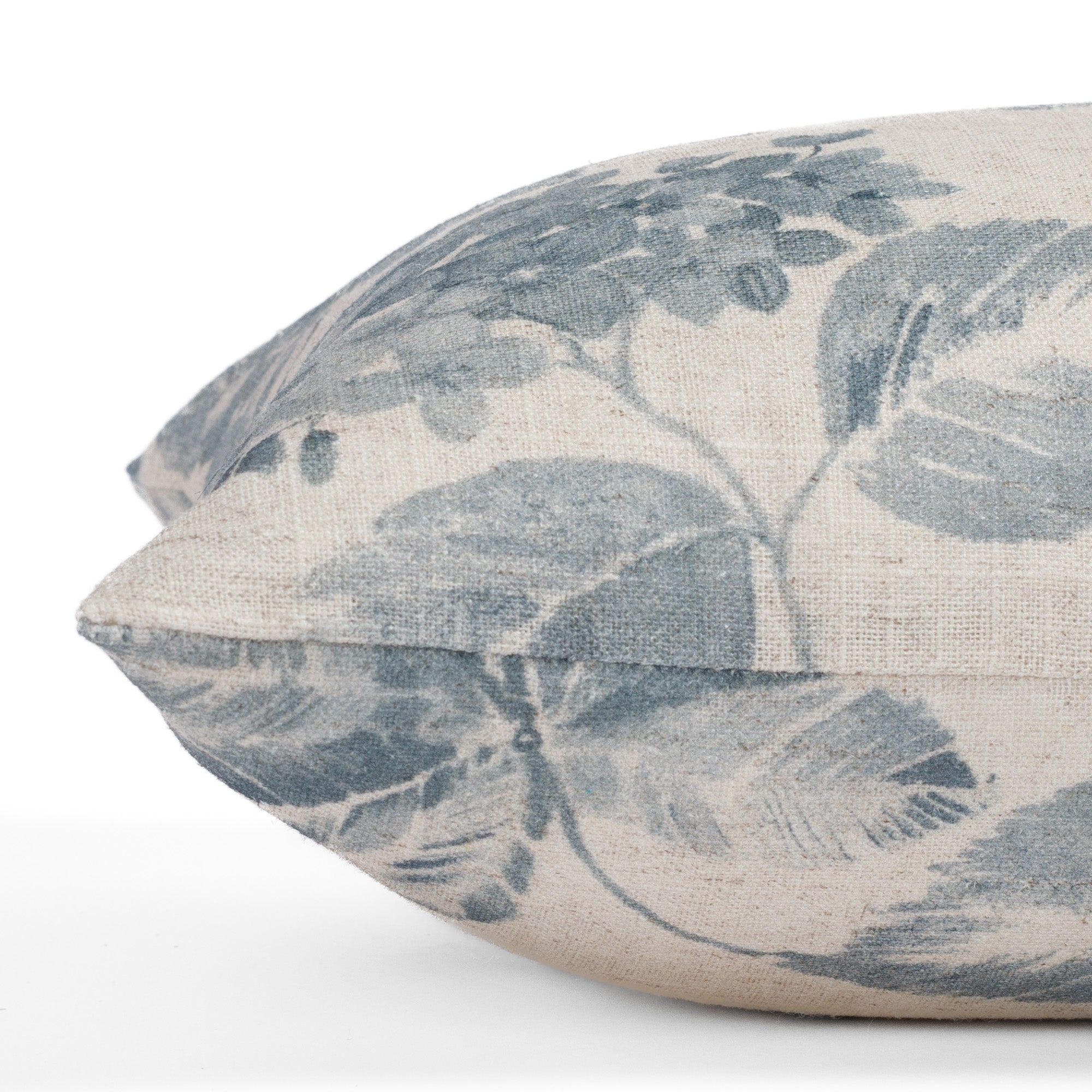 Detailed side close-up of the Heather Indigo 12x24 lumbar pillow from Tonic Living, emphasizing the vintage-inspired floral design and fabric quality in a soft, dusty blue and beige palette.