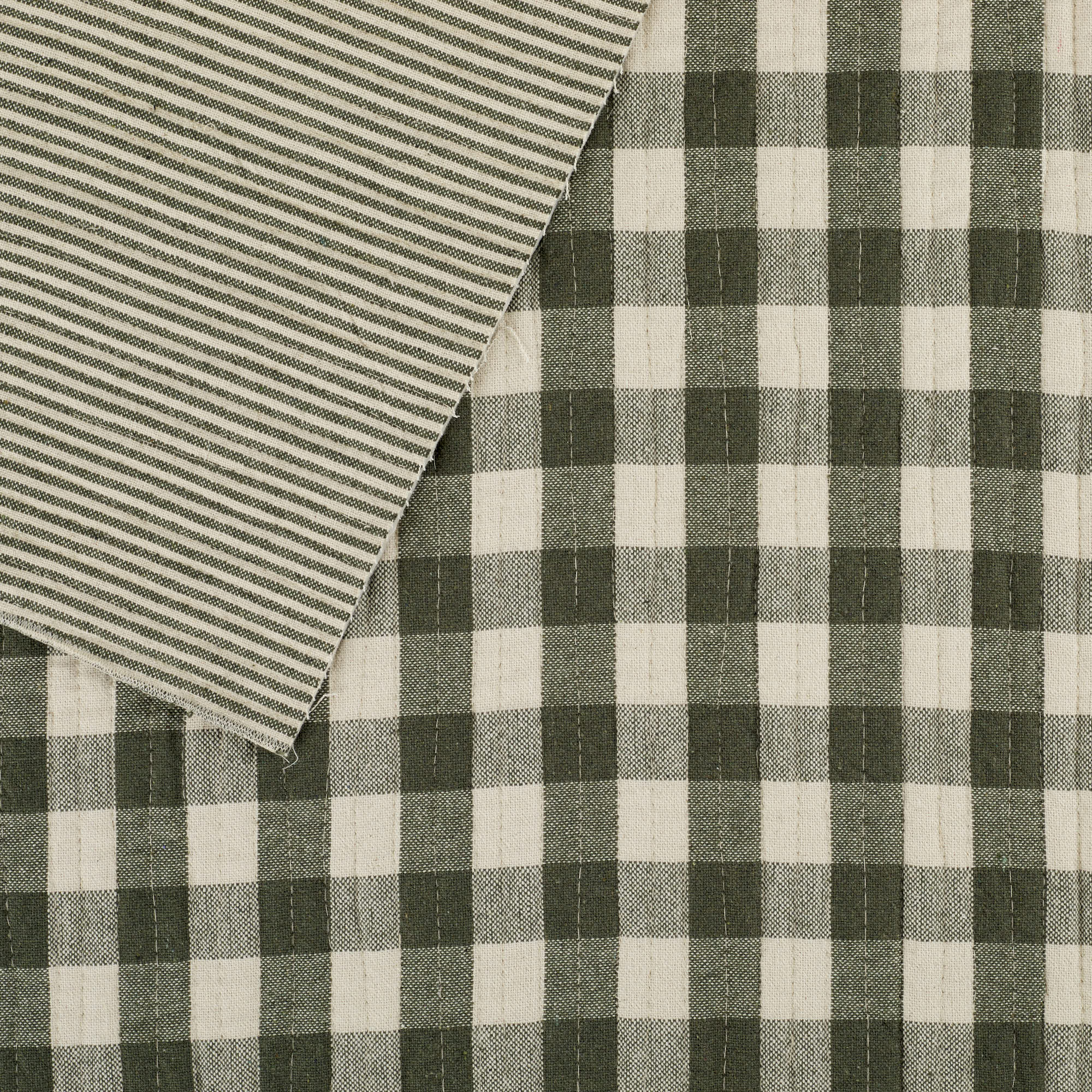 Tonic Living Henry Check Fabric in Forest Green, a quilted matelassé fabric with green gingham check and coordinating stripe reverse.