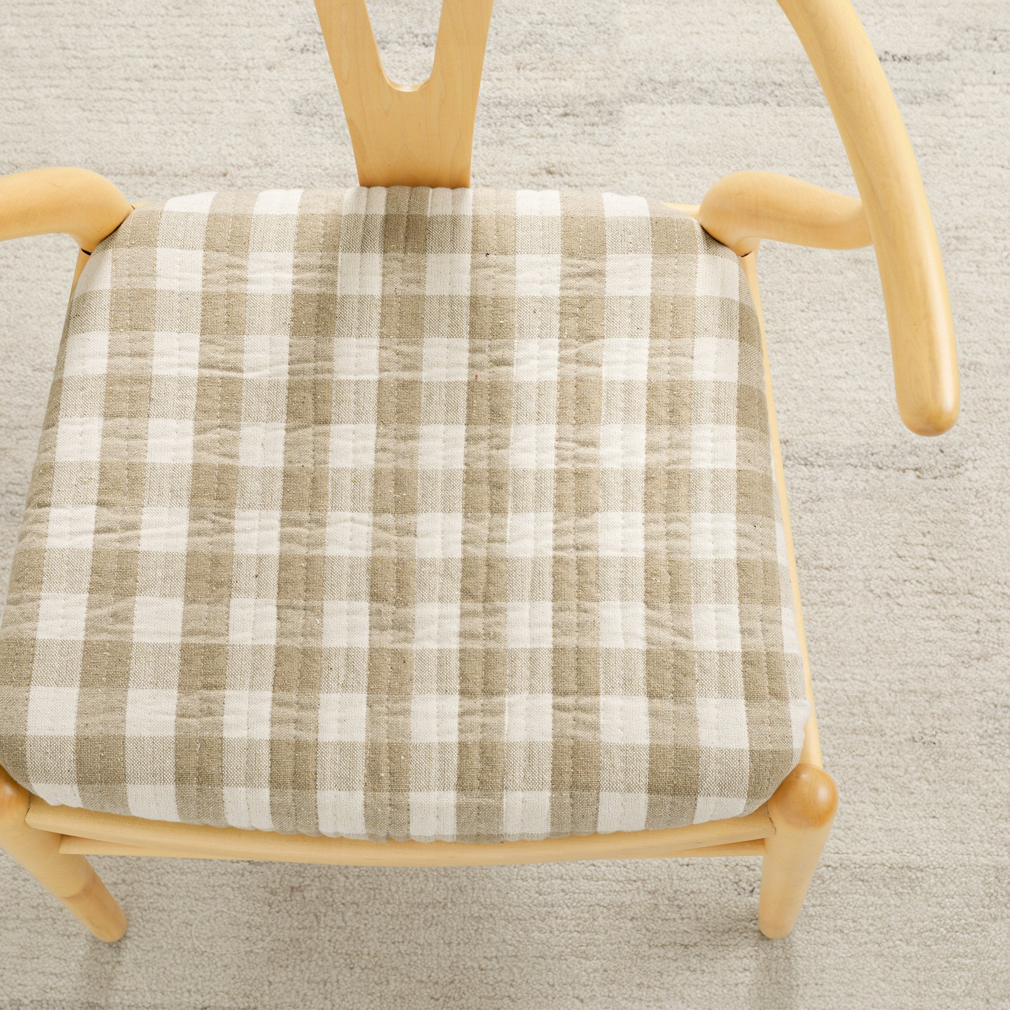 Tonic Living Henry Check Wheat upholstery fabric shown on a chair seat with classic off-white and beige gingham pattern.
