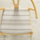 Tonic Living Hopper Stripe Toffee high-performance upholstery fabric on a dining chair seat with toffee brown stripes on beige.