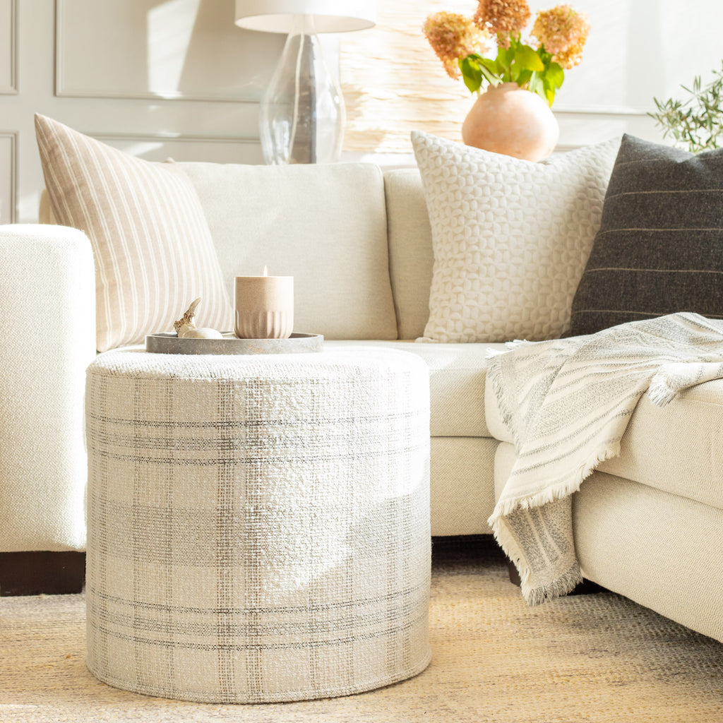 modern neutral throw pillows, round ottoman and blanket from tonic living