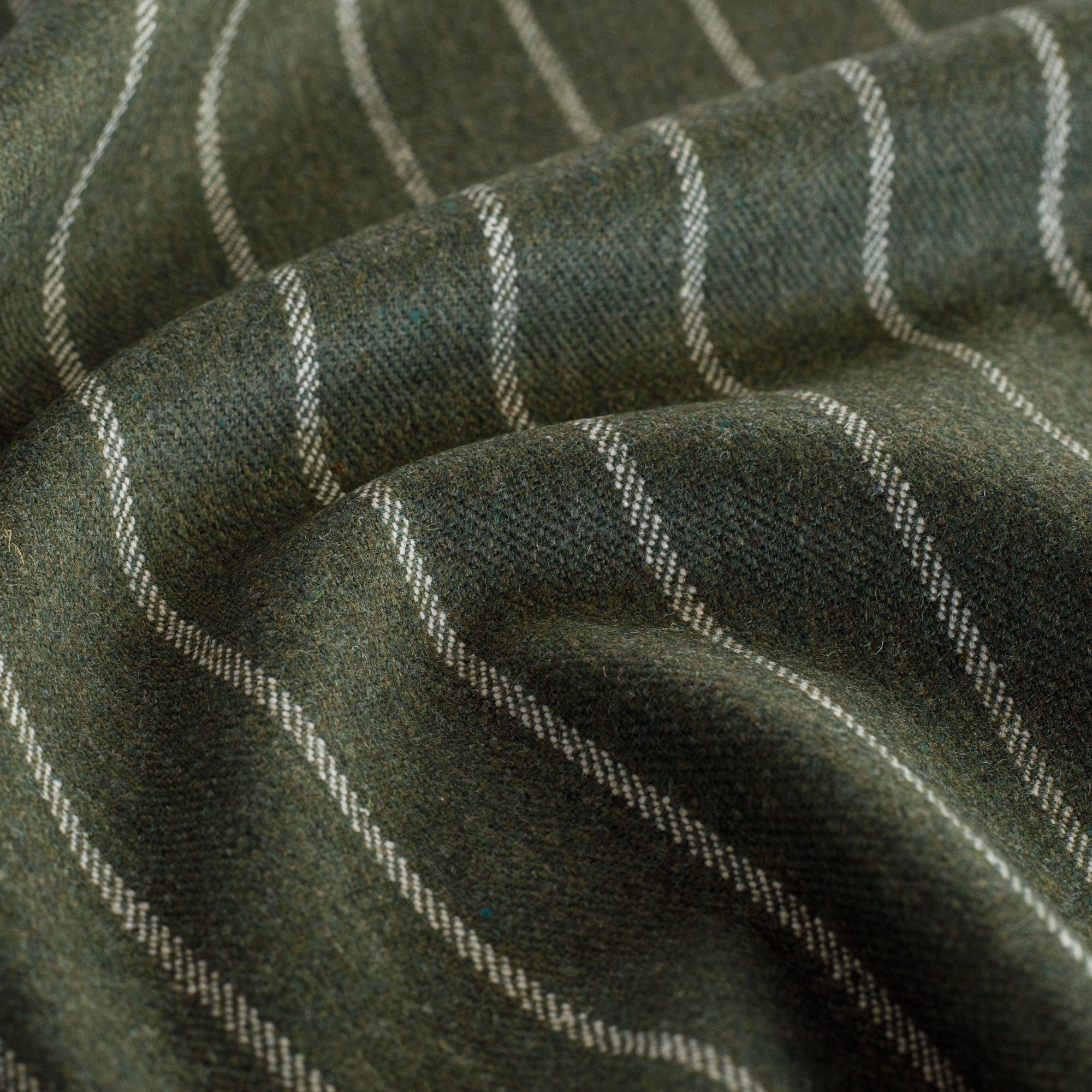 a wool blend moss green and cream vertical pinstripe fabric: close up view