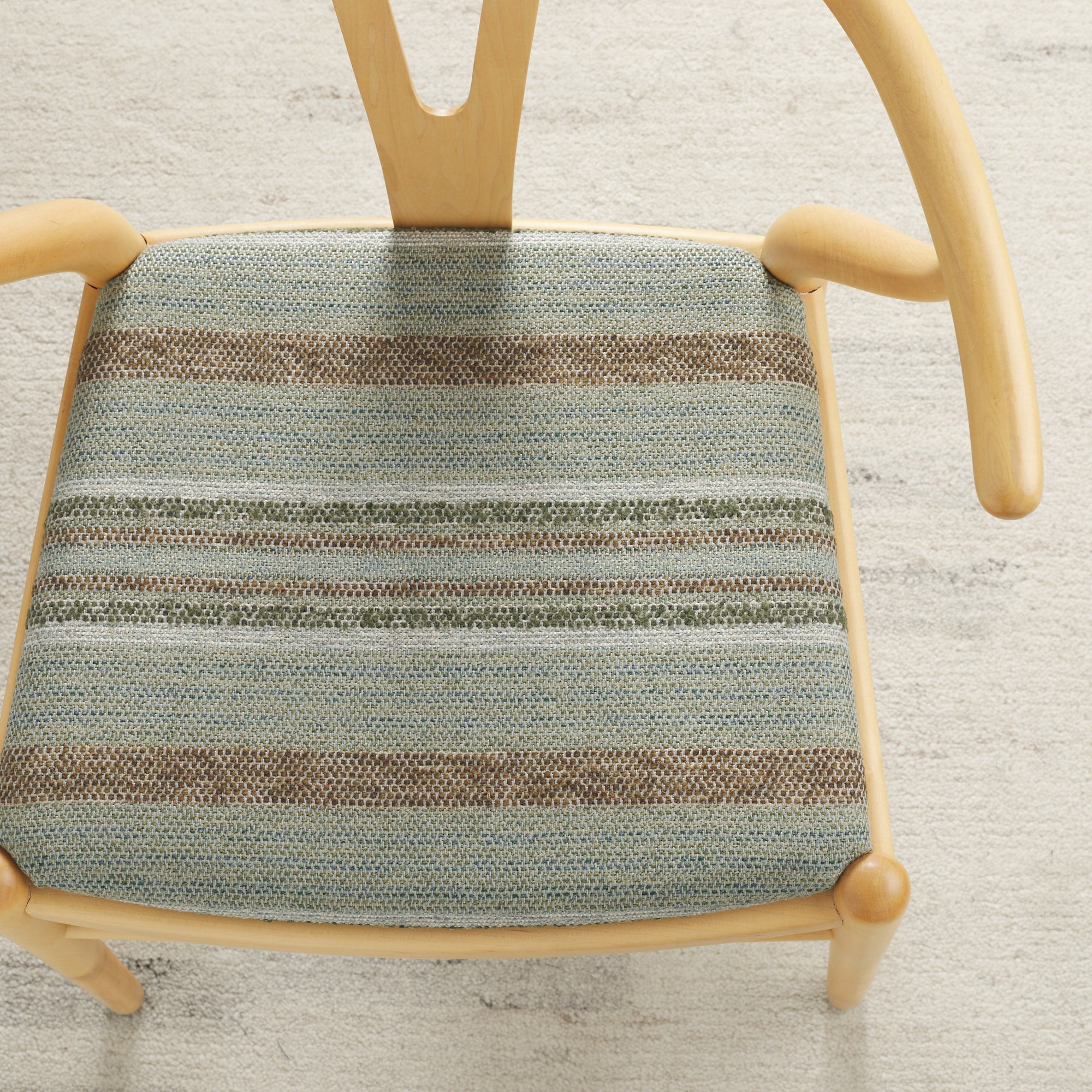 Tonic Living Indie Lagoon high-performance upholstery fabric on a dining chair seat in green-teal textured stripe.