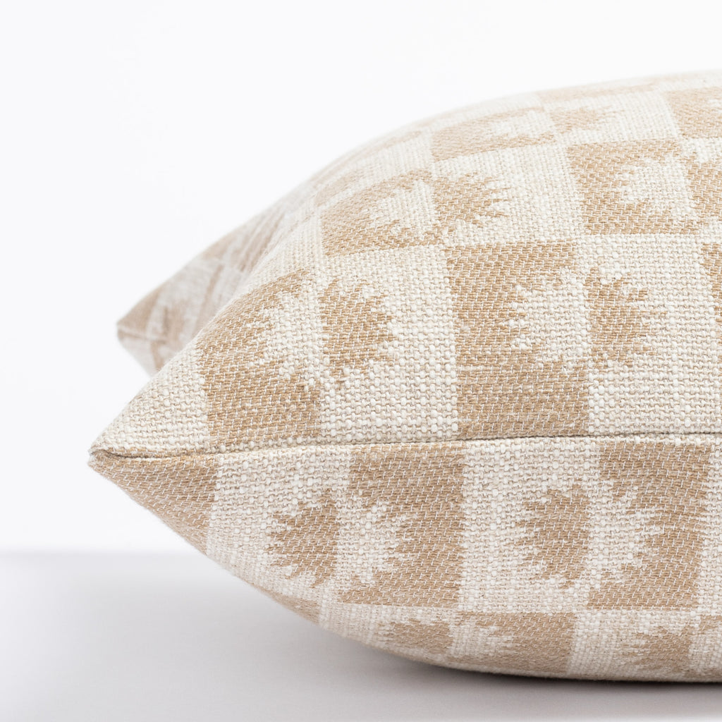 a beige and light brown sun motif checker patterned lumbar throw pillow : close up side view