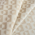 a cream and beige brown checkboard, sun motif patterned upholstery : close up view 2