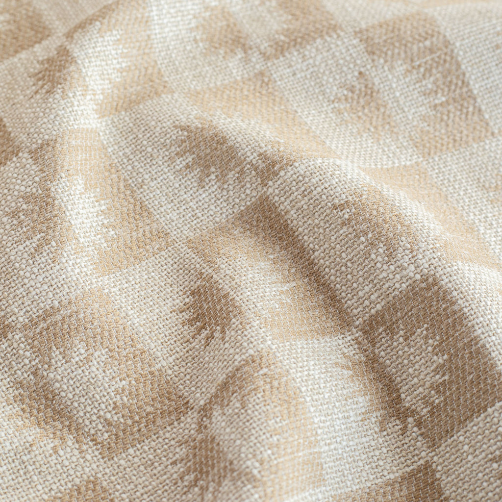 a cream and beige brown checkboard, sun motif patterned upholstery : close up view